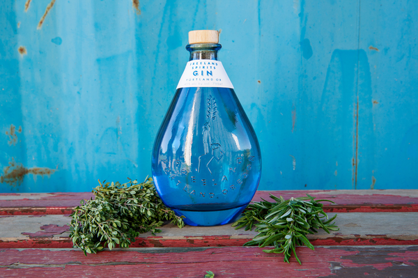 Freeland Spirits blue bottle Gin with botanicals. Distilled in Portland, OR. 