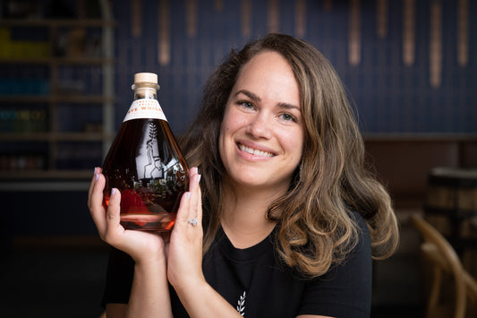 Freeland Spirits Master Distiller, Forbes 30 Under 30, Molly Troupe holding bottle of limited-edition Freeland Rye Whiskey bottled in bond. Portland, Oregon distillery. 
