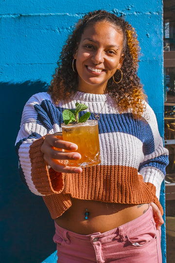 Kendra Purifoye at Freeland Spirits in Portland, OR smiling with Freeland Bourbon cocktail in honor of Black History Month called 