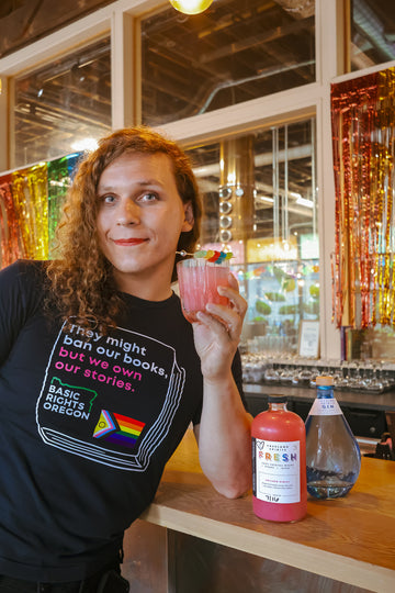 Freeland Spirits Free Spirit Q3 Madeleine Oiseau of Basic Rights Oregon, holding a cocktail at Freeland Spirits tasting room and distillery