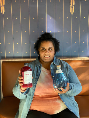 Brooke Golden holding bottle of Persephone's Potion cocktail mixer and Freeland Gin